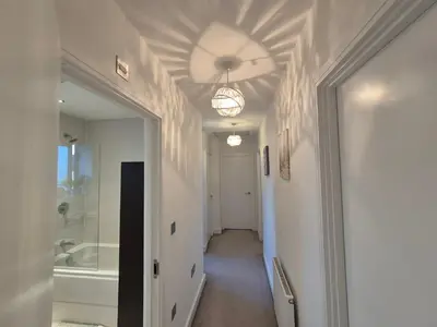 a hallway with a bathroom with a tub and a ceiling at Double Room in a shared 4 bedroom family home in Broomfield in Chelmsford