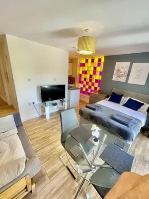 a living room with a bed and a table at 1 Bed Studio - Sleeps 2 - Parking - Wifi in Cambridge