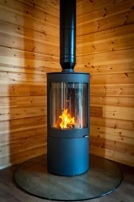 a stove in a room with a fire in it at Meadow Valley Lodge 4 in Ipswich