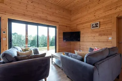 a living room with two couches and a television at Meadow Valley Lodge 4 in Ipswich
