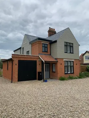 a house with a garage and a brick building at The Sunset Nook in Ipswich