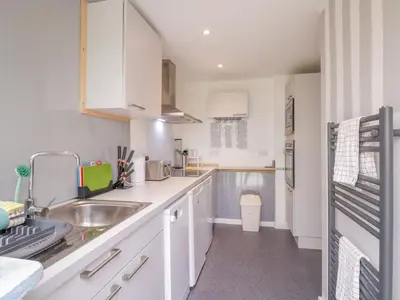 a kitchen with white cabinets and a sink at The Annex in Colchester