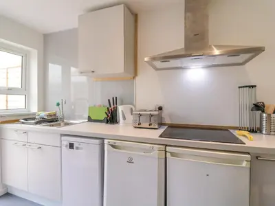a kitchen with white cabinets and a sink at The Annex in Colchester