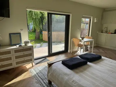 a bedroom with a bed and a kitchen with a table at Gorgeous studio! in Cherry Hinton