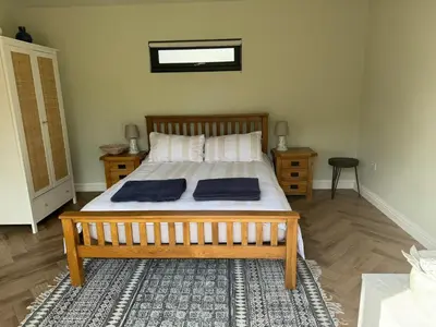 a bedroom with a bed with two pillows on it at Gorgeous studio! in Cherry Hinton