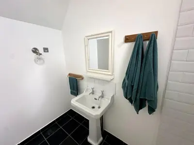 a white bathroom with a sink and a mirror at Mersea best kept secret in Colchester