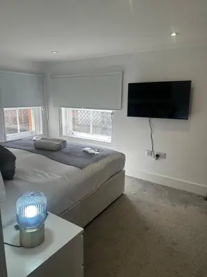 a bedroom with a bed and a flat screen tv at Relaxing 1 bedroom garden flat. in Brentwood