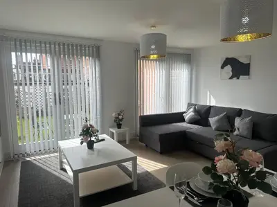 a living room with a couch and a table at Relaxing 1 bedroom garden flat. in Brentwood
