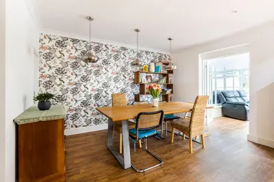 a dining room with a table and chairs at En-suite with double bed on mezzanine and desk in family home in Hertford