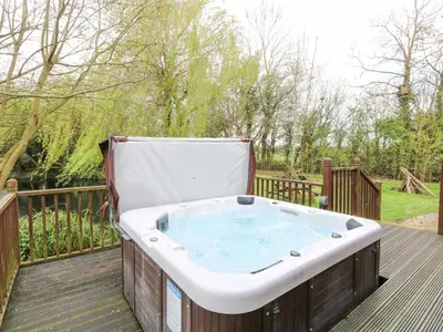 a hot tub sitting on a wooden deck at Kingfisher Lodge in Langham