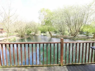 a view of a river from a wooden fence at Kingfisher Lodge in Langham