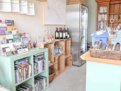 a store with a refrigerator and a shelf with books at Heron Lodge in Langham