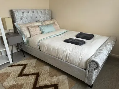 a bed in a room with a bed frame and a rug at Cozy 3 bedroom bungalow in rural location in Ashwell