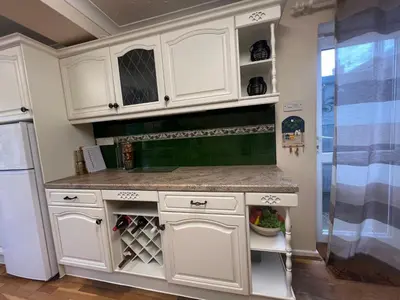 a kitchen with white cabinets and a refrigerator at Cozy 3 bedroom bungalow in rural location in Ashwell