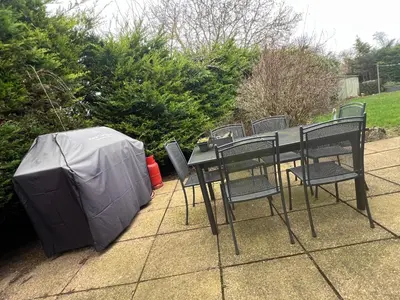 a table and chairs with a television on a patio at Cozy 3 bedroom bungalow in rural location in Ashwell