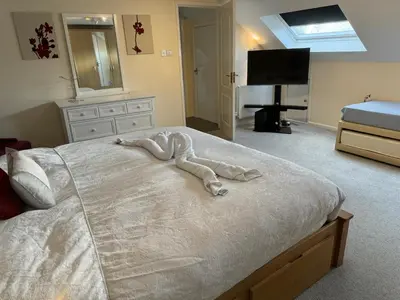 a bedroom with a bed with a white comforter at Cozy 3 bedroom bungalow in rural location in Ashwell
