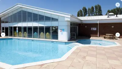 a large swimming pool in front of a building at Seaview Caravan 2 Bedroom Sleeps 6 -WiFi -Smart Tv in Colchester