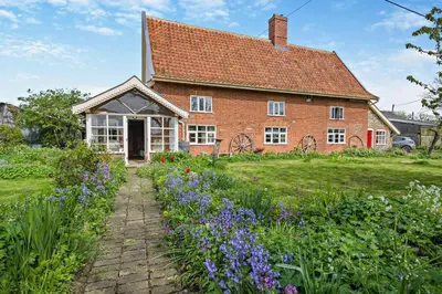 a brick house with flowers in front of it at 3 Bed in Rumburgh oc-c27094 in Rumburgh