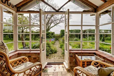 an empty conservatory with windows and a view of a garden at 3 Bed in Rumburgh oc-c27094 in Rumburgh