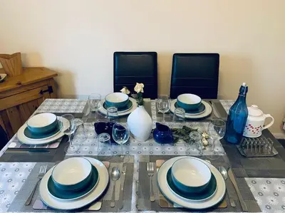 a table with blue and white plates and utensils at Contractors and families welcome in Earith