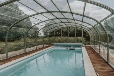 a large swimming pool with a glass roof at Restaries at Paradise Farm in Halesworth