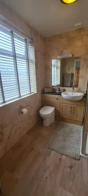 a bathroom with a sink and a toilet and a mirror at Carolines rooms in Cherry Hinton