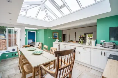 a kitchen and dining room with a table and chairs at Myrtle Cottage 4 in Friston