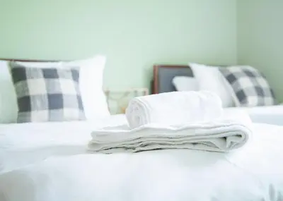 a pile of towels sitting on top of a bed at Stylish 3x bed house in Soham in Soham