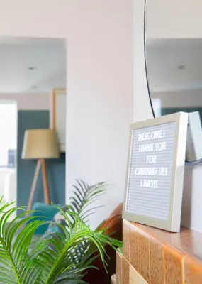 a sign sitting on a table next to a plant at Stylish 3x bed house in Soham in Soham