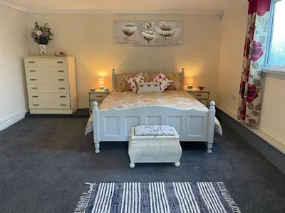 a bedroom with a bed and two dressers and a drawer at Ivy Cottage in Salters lode
