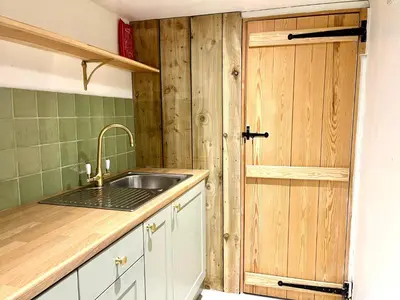 a kitchen with a sink and a wooden door at Willow Barn, Long Melford in Long Melford