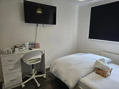 a bedroom with a bed and a desk and a desk and chair at Jays-Rooms in Pitsea