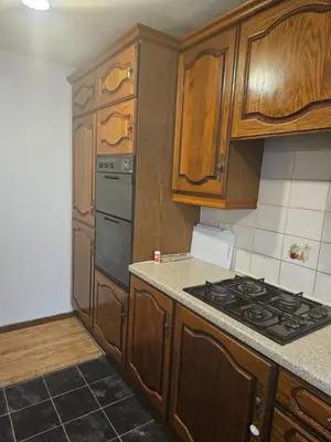 a kitchen with wooden cabinets and a stove top oven at Jays-Rooms in Pitsea