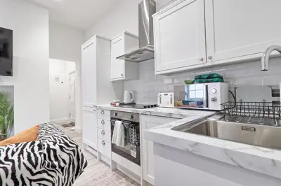 a kitchen with white cabinets and a sink at Chelmsford City Central Ground Floor Apartment Next To Town Centre in Chelmsford