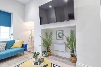 a living room with a blue couch and a table at Chelmsford City Central Ground Floor Apartment Next To Town Centre in Chelmsford