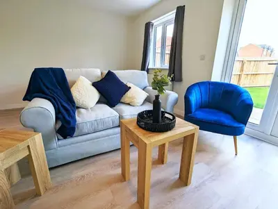 a living room with a couch and a blue chair at 3-Bed, Sleeps 6, 3 Bath, Parking, WiFi in Watton