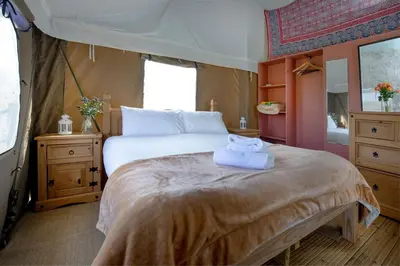a bedroom with a large bed with towels on it at Kestrel - Sweffling Hall in Rendham