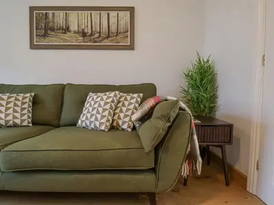 a green couch with pillows on it in a living room at 23 Church Farm Lane in Halesworth
