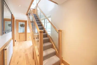 a staircase in a house with wooden railings at 5 Toller Close, Orford in Orford