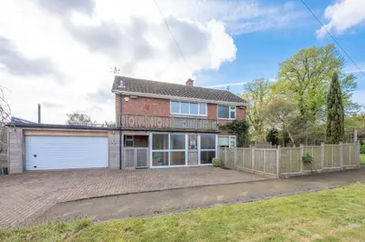 a brick house with a garage and a fence at 5 Toller Close, Orford in Orford