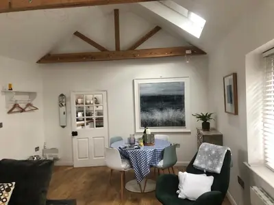 a living room with a table and chairs at The studio spring house in Alderton