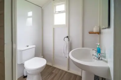 a white bathroom with a toilet and a sink at Linnet - Sweffling Hall in Rendham
