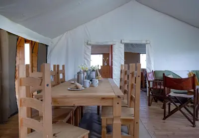 a wooden table and chairs in a tent at Skylark - Sweffling Hall in Rendham