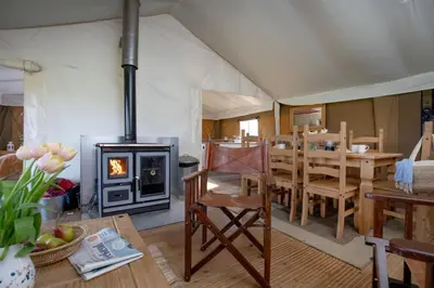 a tent with a dining room and a fireplace at Swallow - Sweffling Hall in Rendham