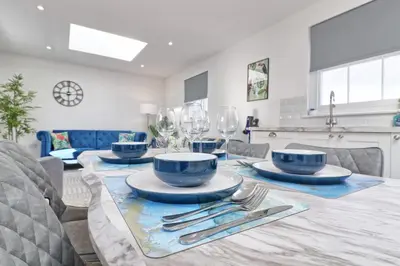 a dining room with a table with plates and silverware at Chelmsford City Centre Modern Duplex With Parking, Wi-Fi & Netflix in Chelmsford