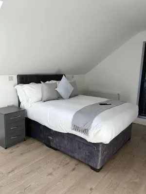 a bedroom with a large bed with white sheets and pillows at Cosy nook in Hardwick