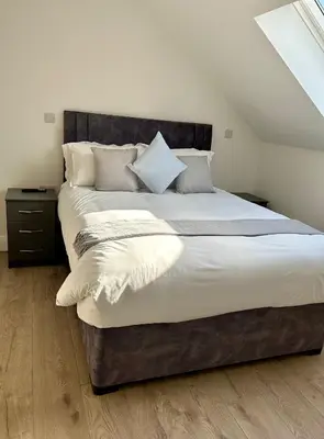 a bedroom with a large bed with white sheets and pillows at Cosy nook in Hardwick
