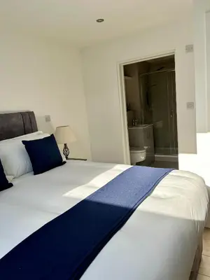 a bedroom with a large bed with blue and white sheets at Cosy nook in Hardwick