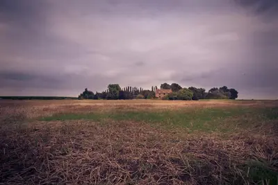 a field with a house in the middle of it at Unique glamping experience near Ely & Cambridge in Ely