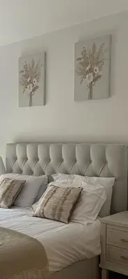 a white bed with two pictures on the wall at The Melodies with Free Parking , Harlow in Harlow